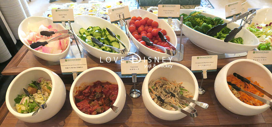 東京ディズニーランドホテル、シャーウッドガーデン・レストラン「ディズニー・クリスマス2025、スペシャルブッフェ」冷たい料理（大根/キュウリ/ミニトマト/ブロッコリー/厚揚げと蕪の柚子胡椒和え/カポナータ/タコと牛蒡のサラダ/キャラットラペ）