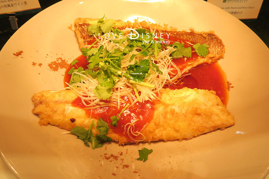 東京ディズニーランドホテル、シャーウッドガーデン・レストラン「ディズニー・クリスマス2025、スペシャルブッフェ」温かい料理（鯛の甘酢餡かけ）