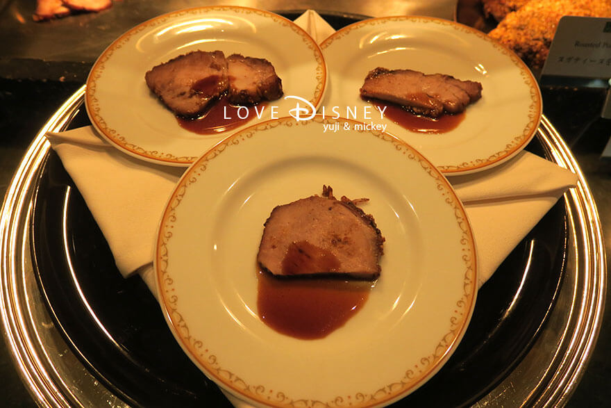 東京ディズニーランドホテル、シャーウッドガーデン・レストラン「ディズニー・クリスマス2025、スペシャルブッフェ」温かい料理（ヌガティーヌを纏ったポークのロースト）