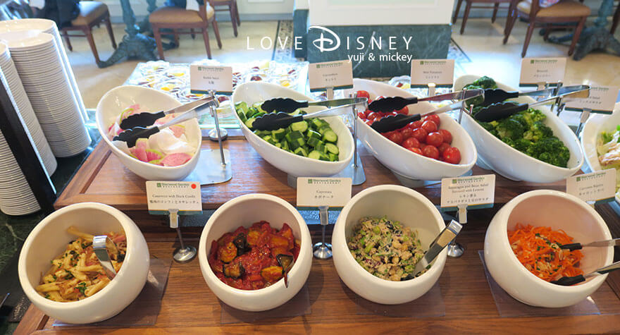 東京ディズニーランドホテル「シャーウッドガーデン・レストラン」ディズニー・パルパルーザ、ヴァネロペのスウィーツ・ポップ・ワールドブッフェ、冷たい料理（大根/キュウリ/ミニトマト/ブロッコリー/鴨肉のコンフィとカサレッチェ/カポナータ/レモン香るアスパラガスと豆のサラダ/キャロットラペ）