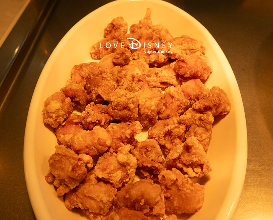 東京ディズニーランド、クリスタルパレス・レストラン「ディズニー・パルパルーザ、ヴァネロペのスウィーツ・ポップ・ワールド」温かい料理（鶏の唐揚げ ネギ塩ダレ）