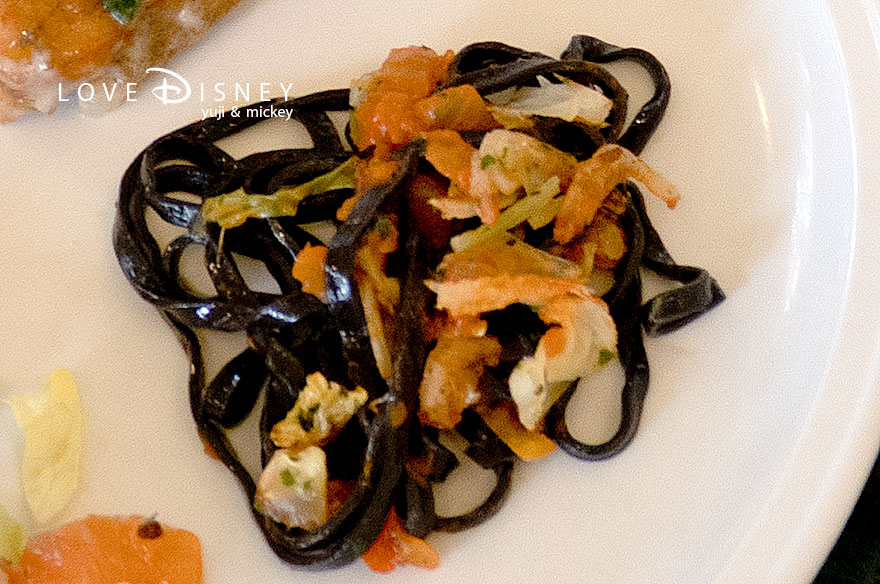 東京ディズニーランド、クリスタルパレス・レストラン「ディズニー・パルパルーザ、ヴァネロペのスウィーツ・ポップ・ワールド」温かい料理（イカ墨パスタ 桜海老のペペロンチーノソース）